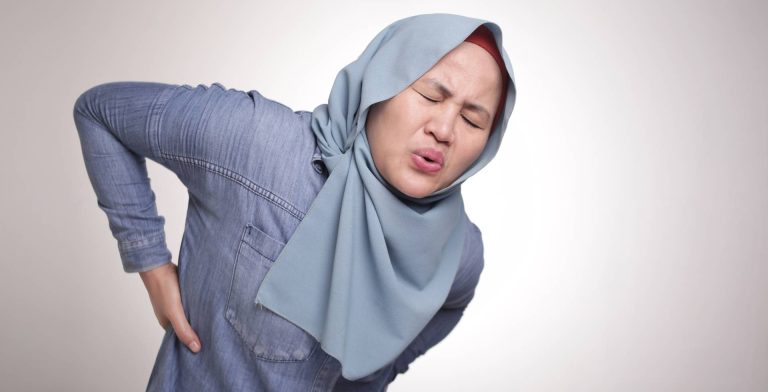 Wanita berhijab mengalami sakit pinggang berkaitan sciatica